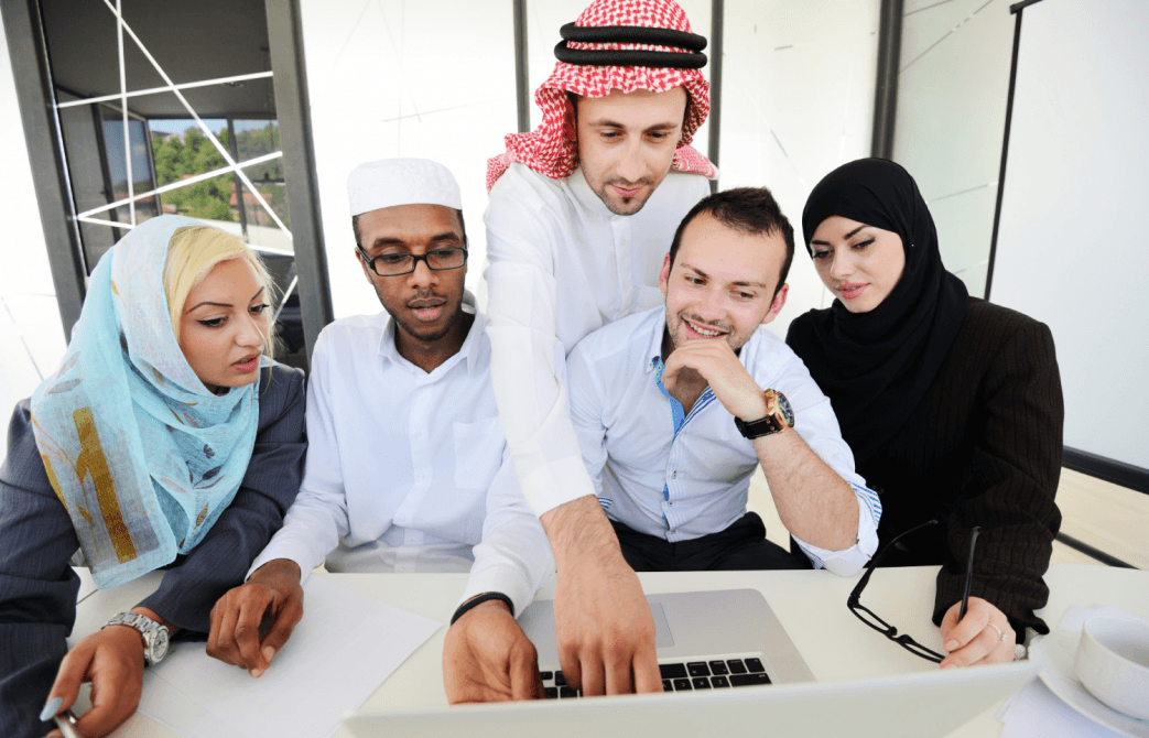 Team gathered around a laptop in an office